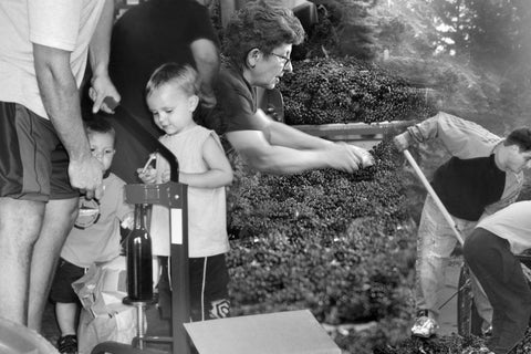 Black and white photo of a family outdoors, possibly gardening or working together.
